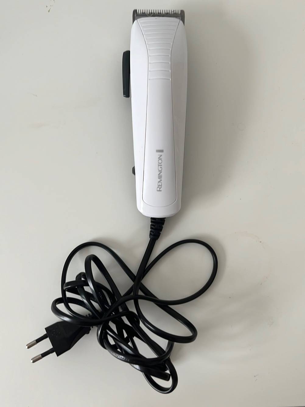 Ein getesteter Remington-Haarschneider von oben inklusiver Kabel auf einer hellen Oberfläche.