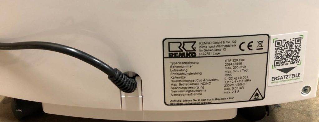 Remko Luftentfeuchter im Test: Detailansicht der Rückseite des weißen Luftentfeuchters inklusive Produktetikett und Kabelanschluss.