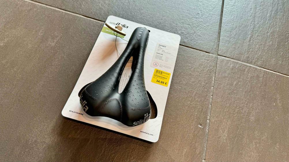 Ein originalverpackter Rennrad-Sattel im Test von oben auf Fließen.