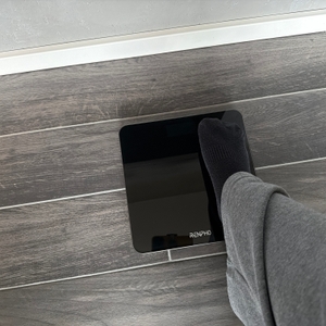 Ein kleiner Fuß steht auf der Renpho BG260R.