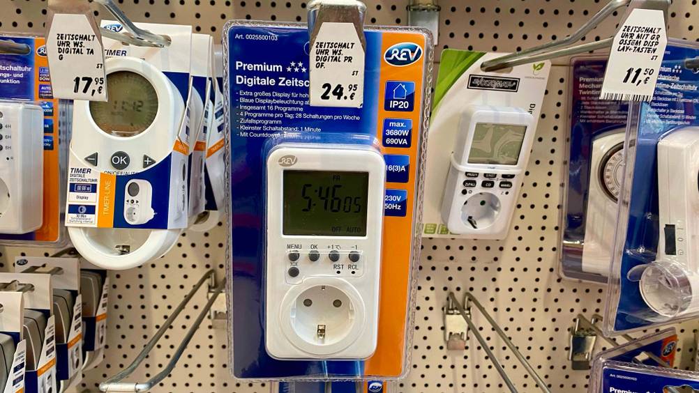 Im Test: Eine Digitale Zeitschaltuhr hängt neben anderen Produkten in einem Regal mit Preisangaben.
