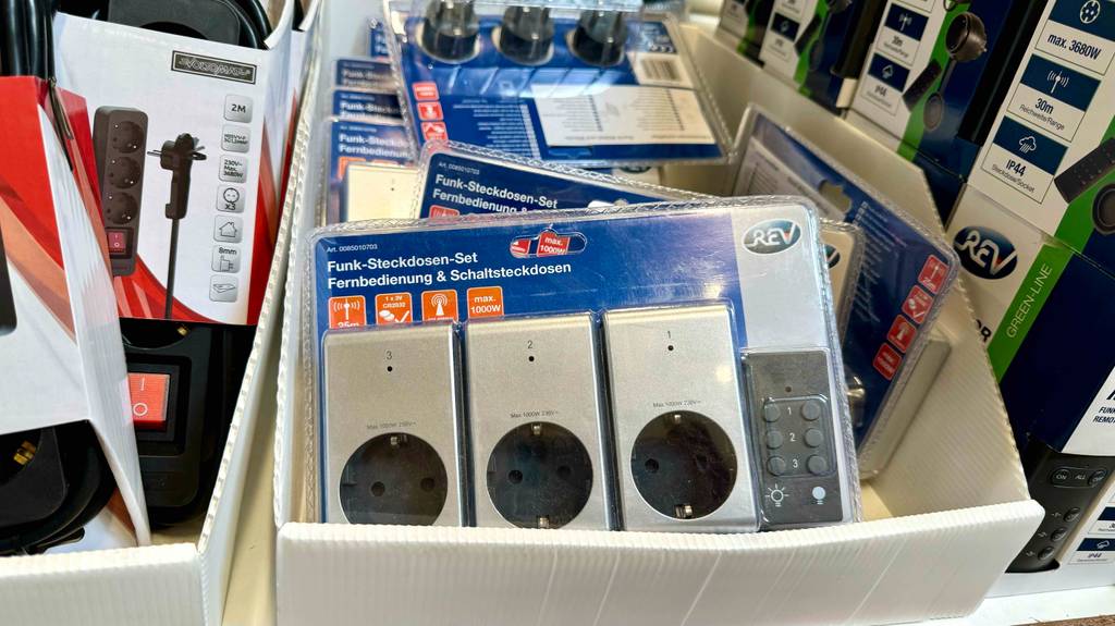 Mehrere Packungen mit Funksteckdosen liegen zum Testen in einem Karton.