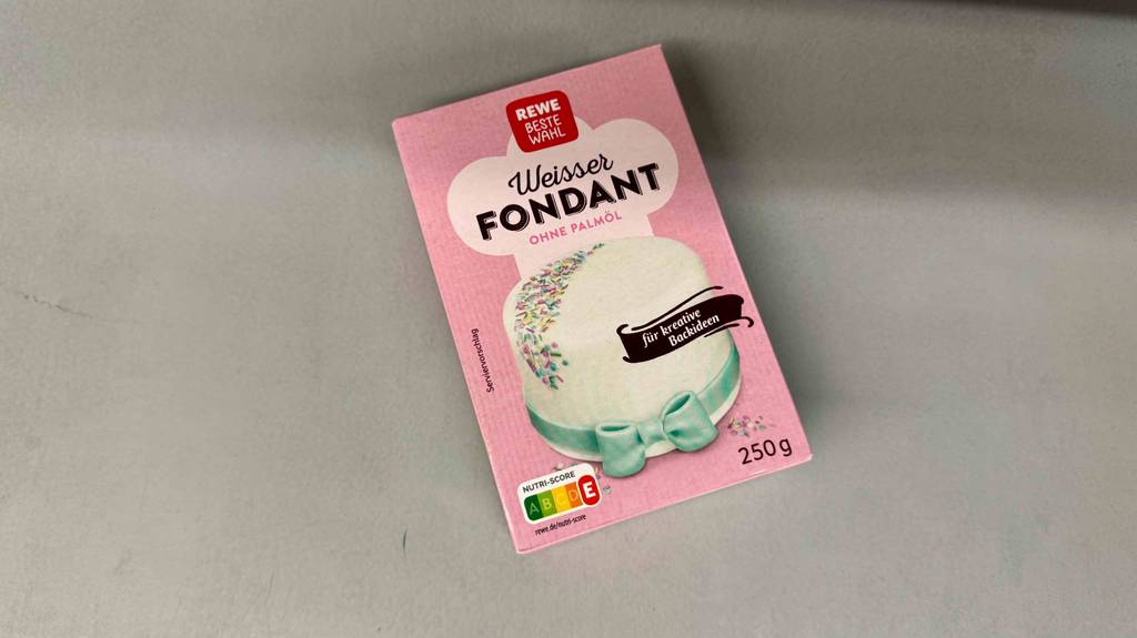 Die Verpackung von getestetem Fondant liegt auf einer hellen Fläche.