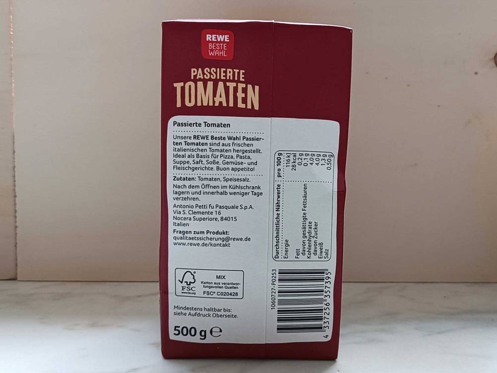 Passierte Tomaten getestet: Rückseite der Origialverpackung mit Zutatenliste vor einer hellen Wand.