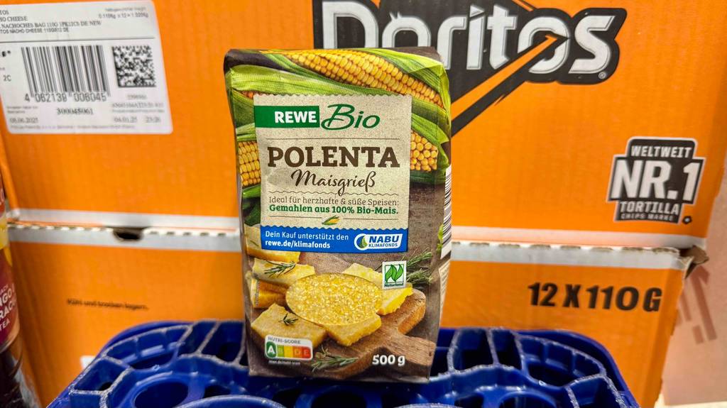 Eine 500-g-Packung mit getesteter Polenta, Maisgrieß, lehnt an einem orangen Lebensmittelkarton.