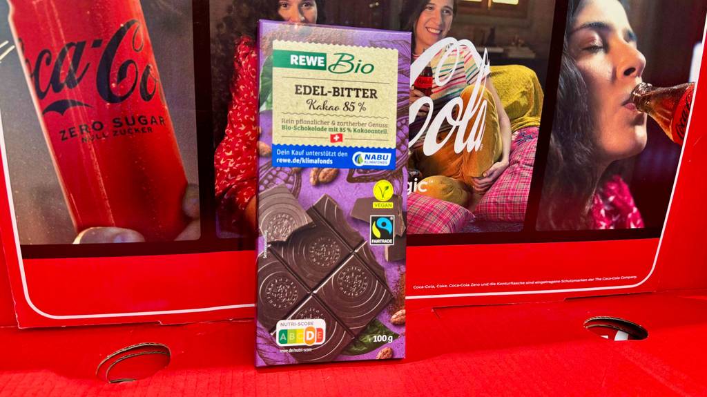 Eine Tafel Schokolade 85% Kakao steht zum testen vor einem Colakarton.