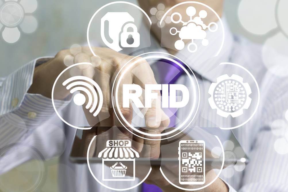 RFID-Blocker im Test: Grafik mit verschiedenen RFID-Symbolen. Dahinter sieht man verschwommen einen Mann mit Tablet.