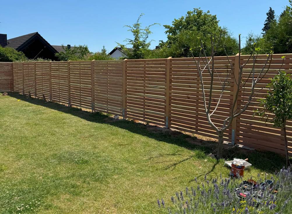 Ein Rhombus-Zaun umgibt einen Garten.