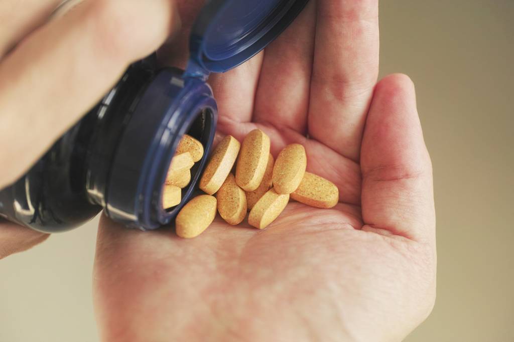 Riboflavin-Test: Eine Person entnimmt Tabletten aus einer Dose. 