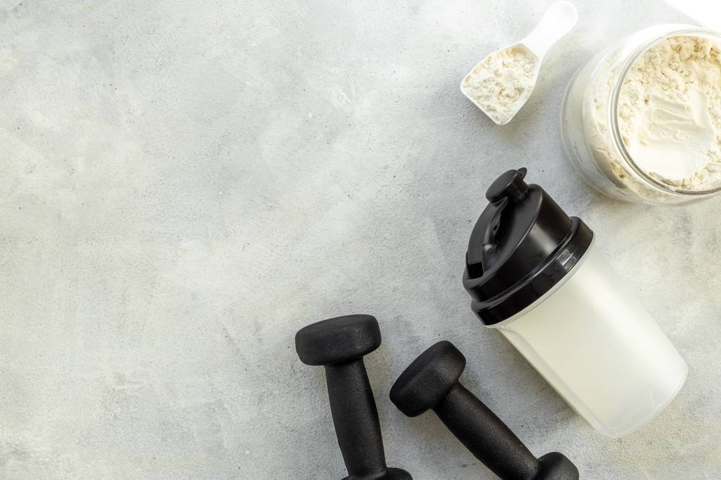 Ribose-Test: Neben Hanteln und einer Sport-Trinkflasche befindet sich eine Dose und ein Löffel mit Ribose-Pulver. 