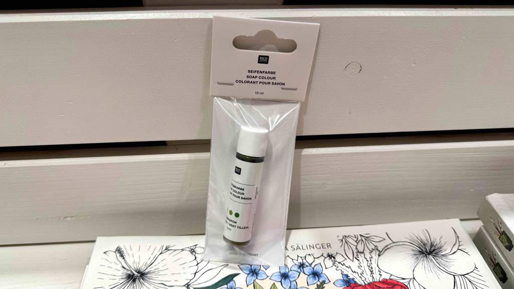 Seifenfarben-Test: Eine 15-mg-Kunststoffflasche in der transparenten Verpackung befindet sich auf einem Malbuch.