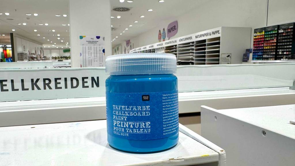 Tafelfarben getestet: Eine Kunststoffdose mit blauer Farbe steht in einem Geschäft für Malerbedarf.