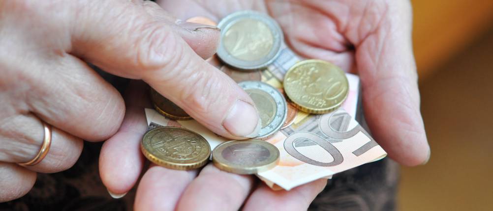 Riester-Rente im Test: Ältere Person zählt Bargeld.