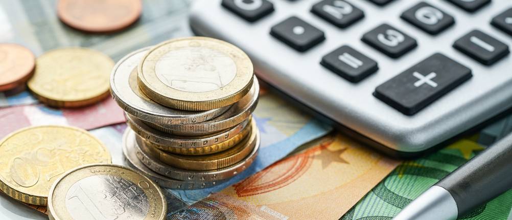 Riester-Rente im Test: Geld liegt neben einem Taschenrechner.