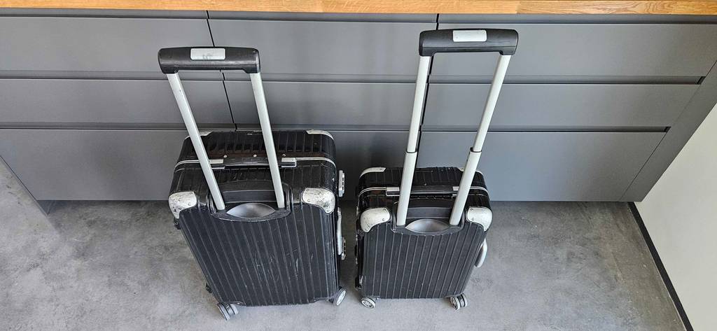 Ansicht von oben auf ein getestetes 2-teiliges Kofferset in Schwarz mit ausgefahrenen Handgriffen.