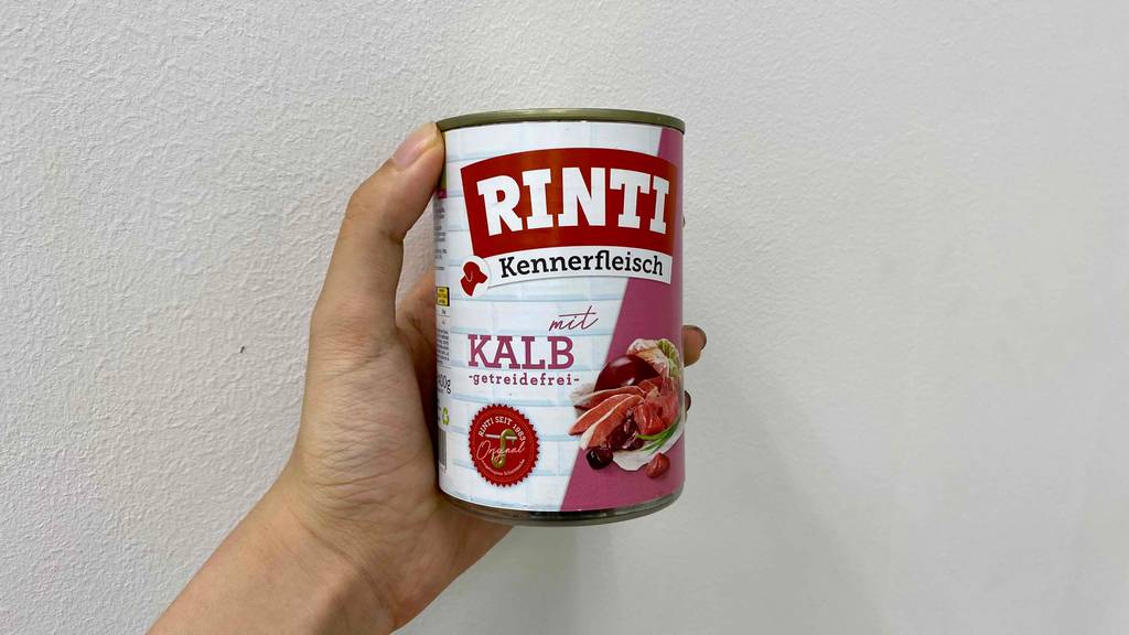 Hand hält eine Dose mit getreidefreiem getestetem Rinti-Nassfutter.