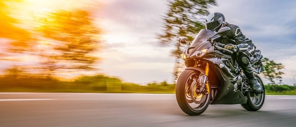 Rippenschutz-Test: Ein Motorradfahrer mit hoher Geschwindigkeit auf einer Straße.