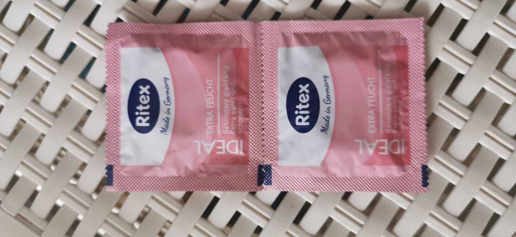 Zwei verpackte Ritex Kondome im Test liegen auf einer weißen Oberfläche.