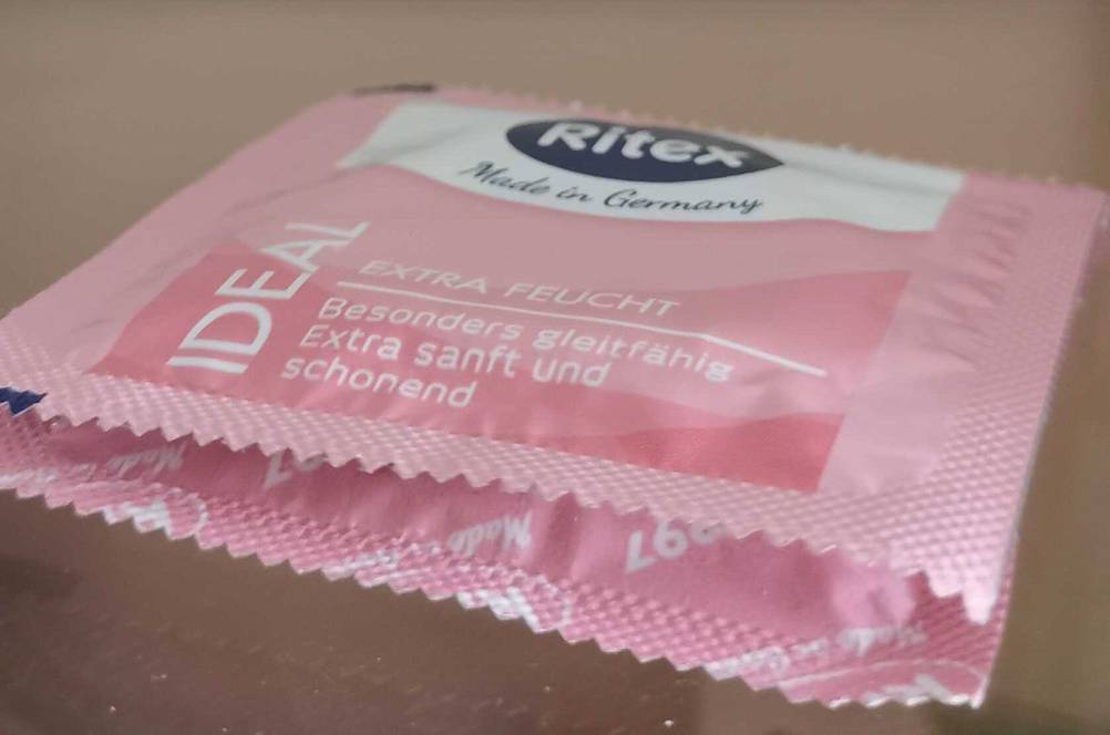Test: Kondome von Ritex liegen in der rosafarbenen Verpackung auf einem Glasregal.