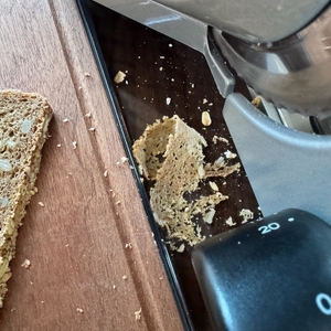 Eine hauchdünne Scheibe Vollkornbrot liegt im Auffangbehälter für Krümel der Ritter E16 Duo Plus