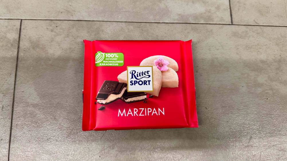 Auf einem Fließenboden liegt eine Tafel der Ritter-Sport-Schokolade im Test.
