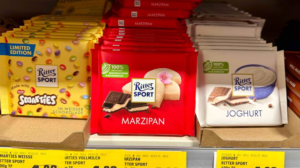 Mehrere Tafeln der getesteten Ritter-Sport-Schokolade in einem Verkaufsregal.