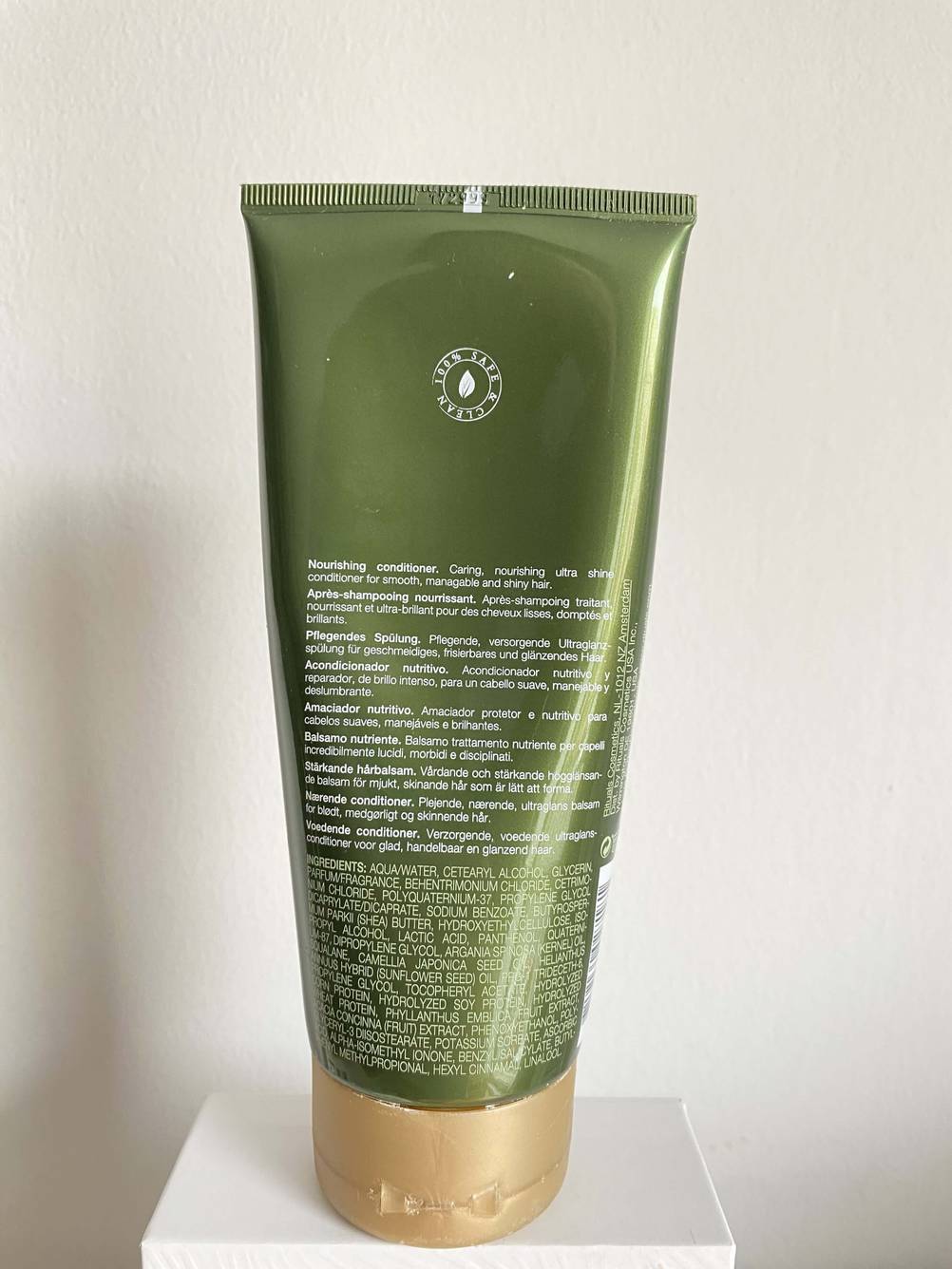Rückseite einer Tube getesteten Conditioners vor einer hellen Wand.