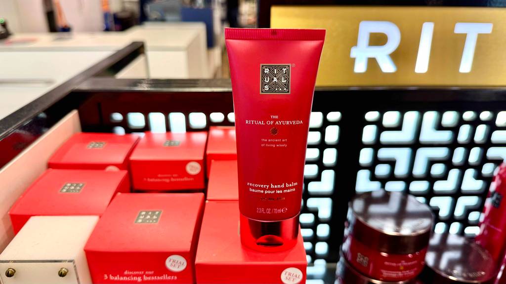 Eine Tube Rituals-Handcreme steht zum testen auf einem roten Karton.