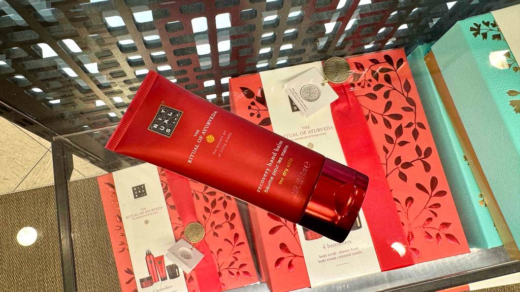 Blick von oben auf eine Tube getestete Rituals-Handcreme, die auf einer Glasfläche liegt.