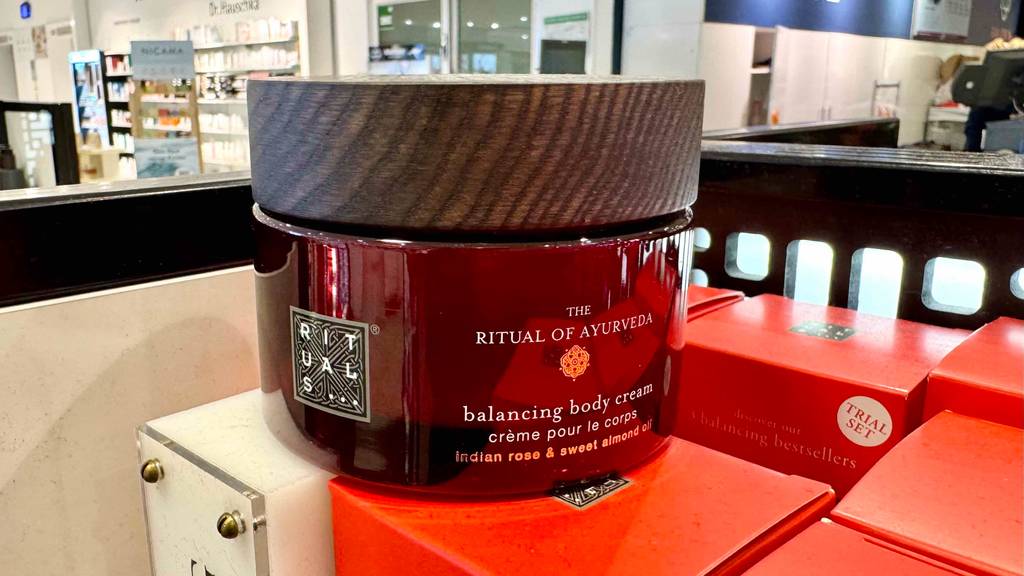 Ein Flakon Rituals-Körpercreme steht zum testen auf einem roten Karton.