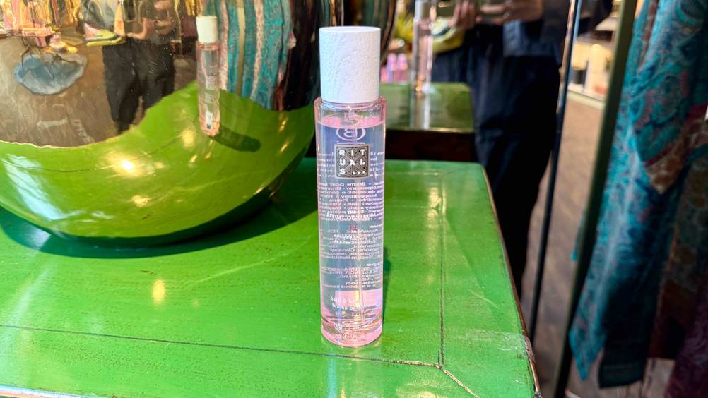 Auf einer grünen Fläche steht eine Flasche des Rituals-Körpersprays im Test.