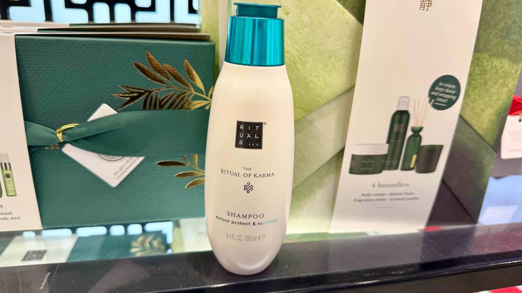 Rituals-Shampoo-Test: eine Flasche steht auf einem Glasregal mit Dekoprodukten.
