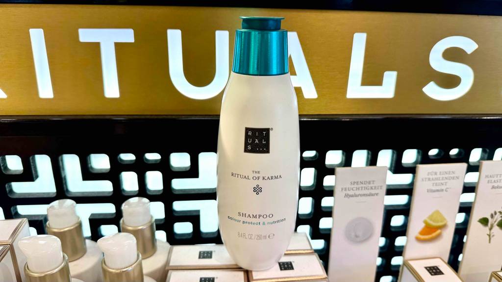 Eine Flasche Rituals-Shampoo steht zum testen auf einem Kosmetikproduktkarton.