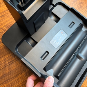 Eine Hand hält die Station vom Roborock Dyad Pro fest