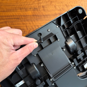 Eine Hand steckt ein Kabel in die Station vom Roborock Dyad Pro