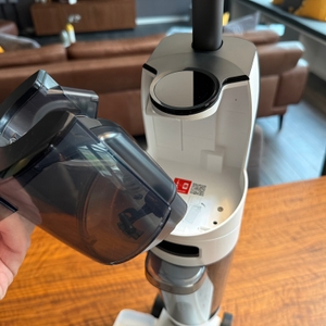 Eine Hand entfernt einen Behälter vom Roborock Dyad Pro