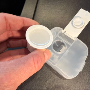 Eine Hand hält eine Kappe vom Roborock Dyad Pro mit Flüssigkeit fest