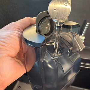 Eine Hand füllt den Wasserbehälter vom Roborock Dyad Pro auf