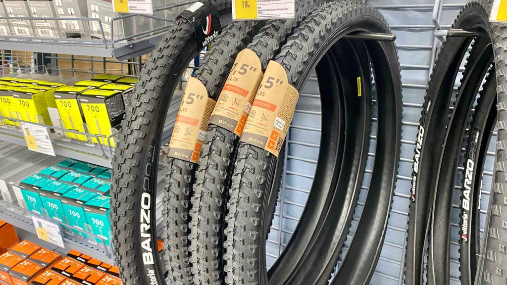 MTB-Reifen 27,5-Test: Mehrere Reifen hängen nebeneinander in einem Regal.