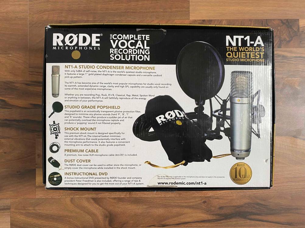 Ein verpacktes Rode PC Mikrofon liegt zum testen auf einer Holzfläche.