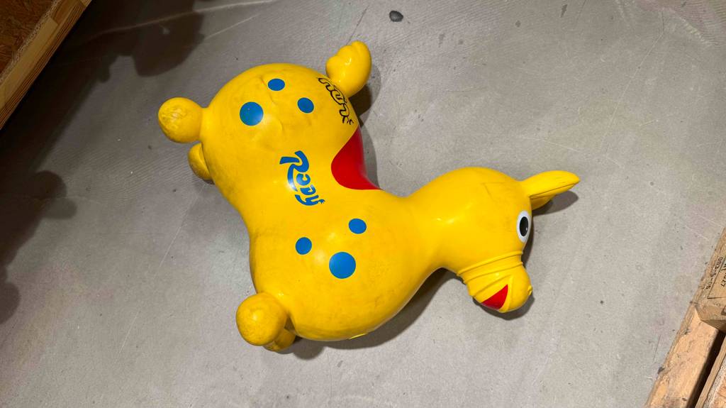 Ein gelbes, getestetes Hüpftier liegt auf einem Zementboden.