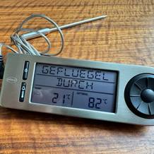 Das Display des Rösle 16283 zeigt "Geflügel durch", eine derzeitige Temperatur von 21 °C und eine Zieltemperatur von 82 °C an, während es auf einem Tisch liegt