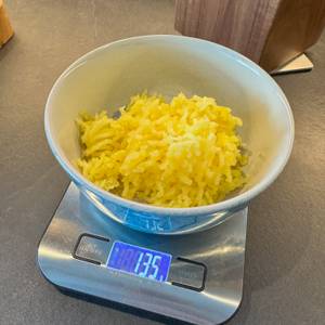 Fertig gepresste Kartoffeln in einer Schale auf einer Waage, die 135 g zeigt.