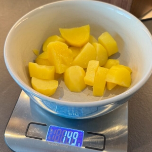 Kartoffeln in einer Schale auf einer Waage, die 149 g zeigt.