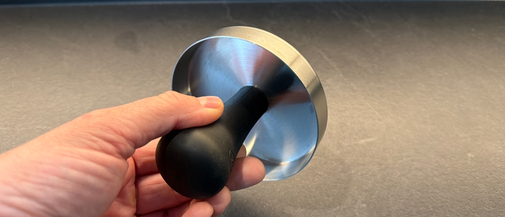 Eine Hand hält den Pressstempel der Rösle-Burgerpresse PRO fest