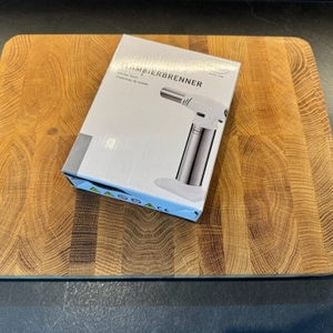 Der Karton des Rösle-Flambierbrenners liegt auf einem Holzbrett