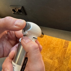 Eine Hand drückt einen Knopf am Rösle-Flambierbrenner