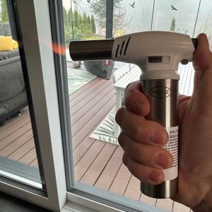 Eine Hand erzeugt mit dem Rösle-Flambierbrenner eine schwache Flamme