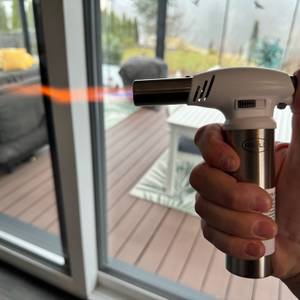 Eine Hand erzeugt mit dem Rösle-Flambierbrenner eine Flamme