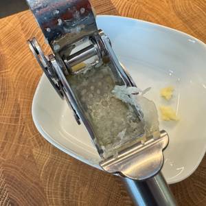 Nahansicht der verbleibenden Knoblauchhaut nach dem Pressvorgang.